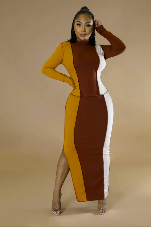 A woman poses in a color blocked top and skirt. 